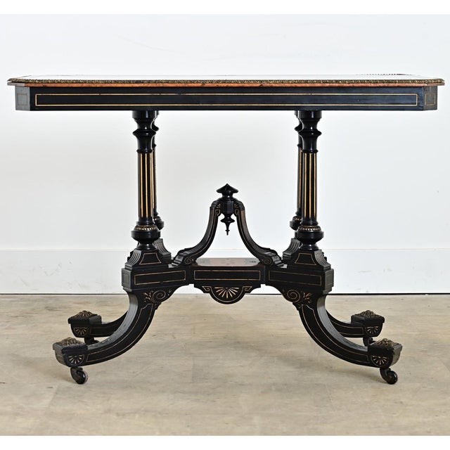 English late 19th century ebonized console or center table that features a variety of angular and curvilinear forms...