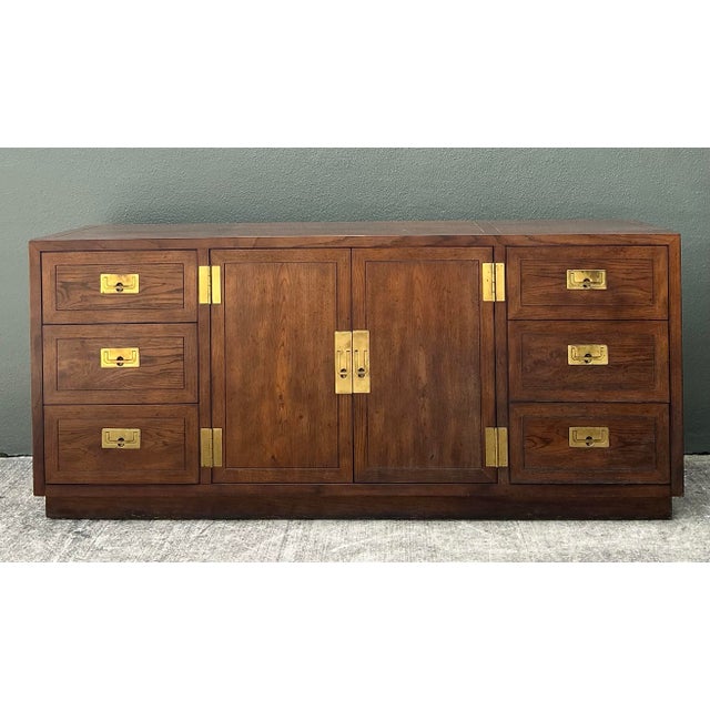 Elevate your interior with this exceptional vintage Henredon credenza, a masterclass in Campaign-style design that blends...
