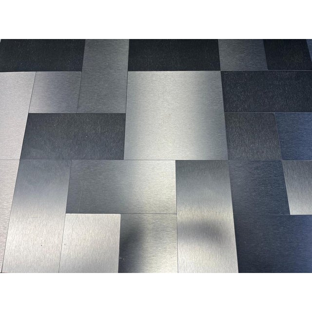 Seventies coffee table with a black lacquer base and a geometrical aluminum top. Good condition with normal age related...