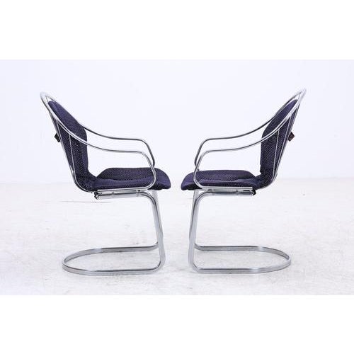 Set of two vintage cantilever chairs by Gastone Rinaldi with an elegantly curved chrome frame and black upholstery. The...