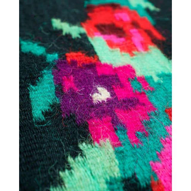 Medium-size vintage handwoven wool rug with a dramatic dark ground and vivid floral “rose” motifs in fuchsia/pink, red and...