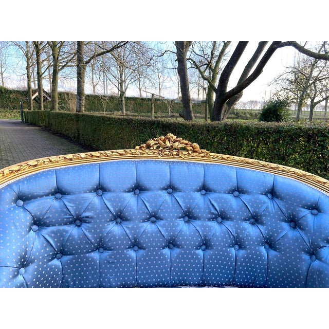 1950s French Louis XVI Style Giltwood Settee in Blue Damask Exuding refined elegance and masterful craftsmanship, this...
