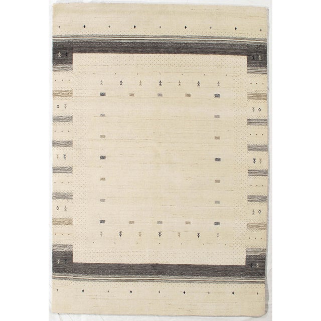 Vintage Hand-knotted Indo Gabbeh rug featuring a soft, neutral field framed by subtle geometric borders in warm gray...