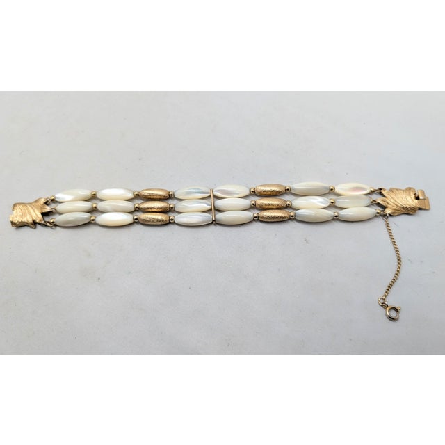 1960s goldtone ellipsoid mother of pearl and textured goldtone beads with small round goldtone spacer beads with...
