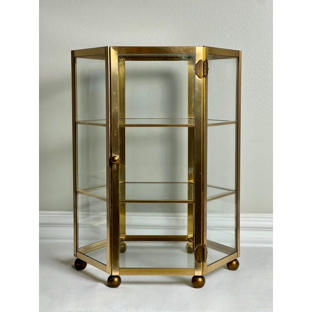1970s high-quality tabletop showcase vitrine with three tiers behind a single hinged door with knob. This sleek, well-made...