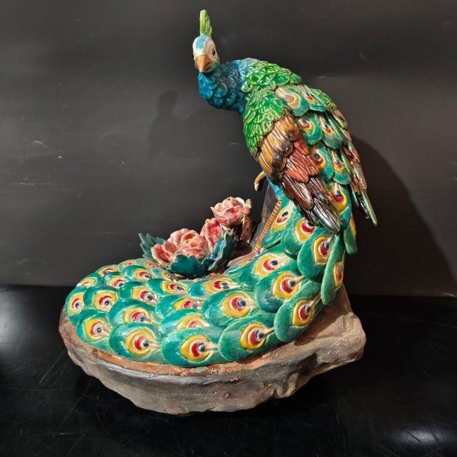 A finely hand-painted ceramic peacock in the Shiwan tradition, shown with its tail spread open, decorated with rich blue,...