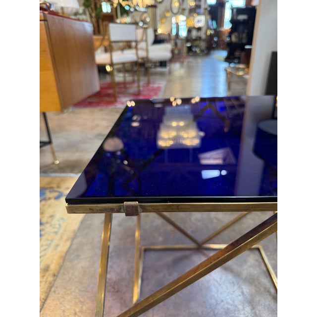 Elegant Italian side table from the 1970s featuring a sculptural brass structure composed of intersecting geometric forms...