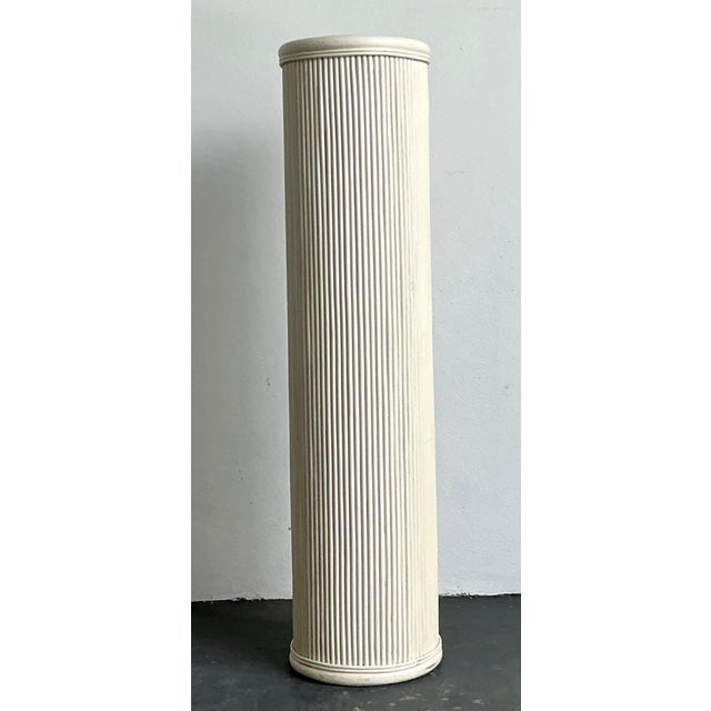 This vintage white painted rattan pedestal is a refined example of mid-20th-century design, characterized by its clean...