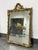 Design Plus Gallery presents an Antique Louis XV Style Gilt Mirror. The mirror has an ornate gilt frame with scrolling...