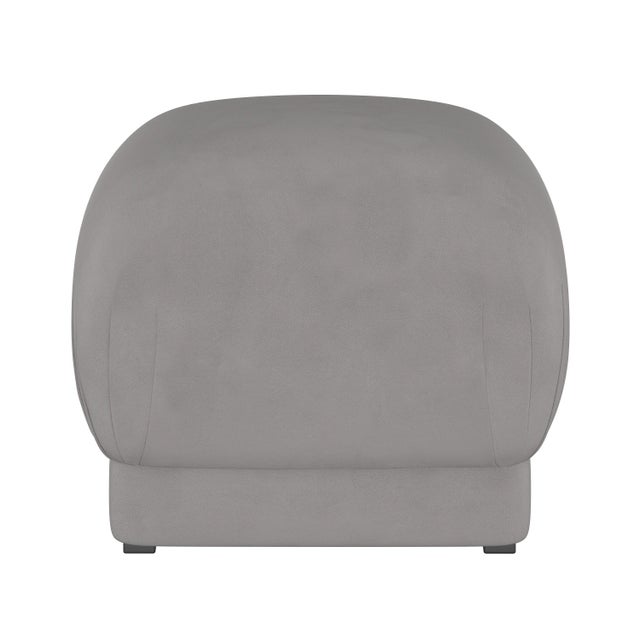 Smooth upholstery covers a sleek cushioned silhouette, accentuated at the corners with delicate handcrafted pleating. The...