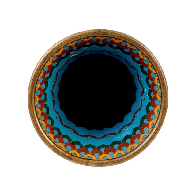 A Japanese enamel vase made using the Cloisonne enamel technique. The vase has the classic shape of an ancient bronze wine...