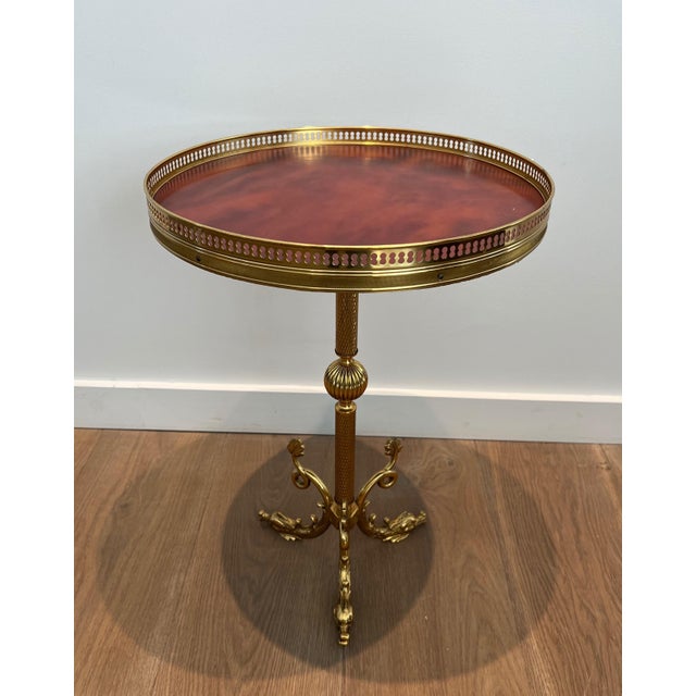 This attractive round neoclassical-style pedestal table is made of brass with a red celluloid lid. It is a French work...
