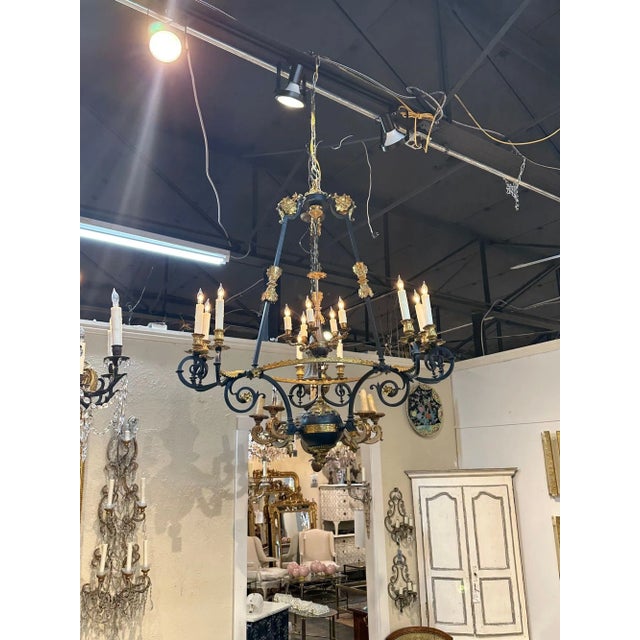 19th century French Empire gilt bronze and black steel 14-light chandelier. Circa 1880. The chandelier has been...