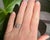 A delicate and intricate swirl ring from the Belle Époque era (circa 1900), crafted in platinum. At its center, it...