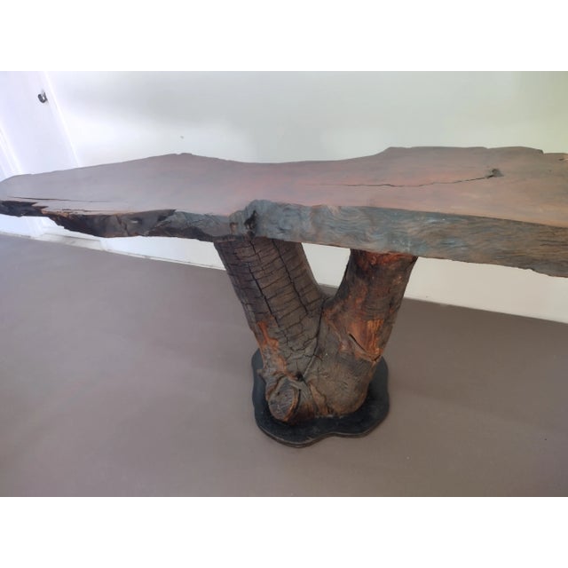 This console table is made from a slab of walnut would that sits on a tree log The size of it makes it outstanding...