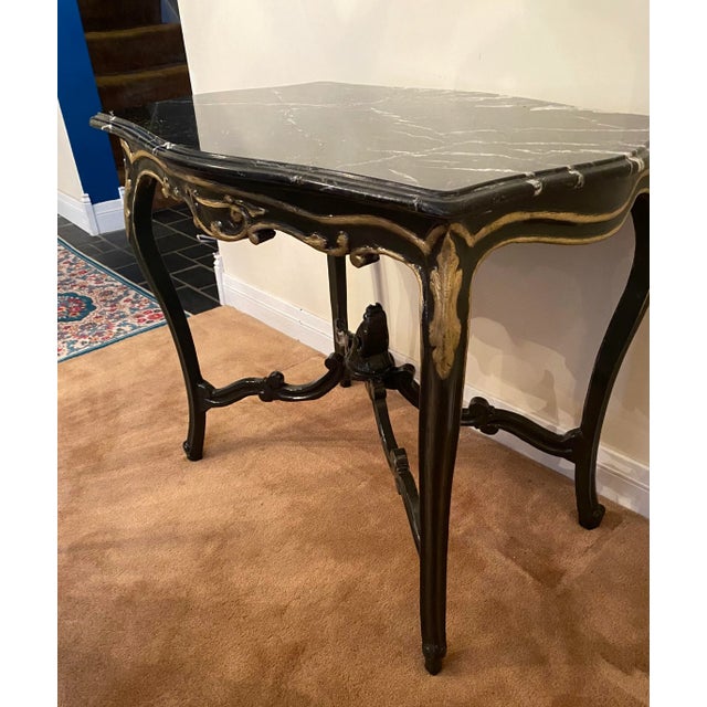 This lovely antique Italian accent table has A turtle shaped black marble top. The marble has a crack that has been...
