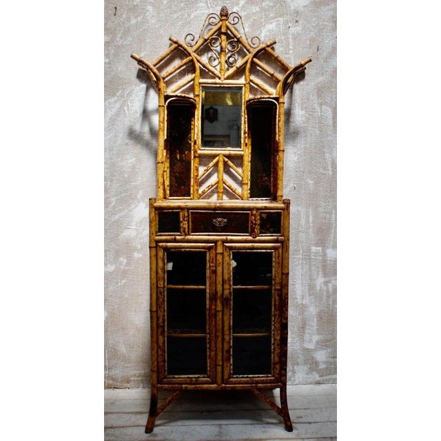 Victorian Glazed Bamboo Display Cabinet, circa 1880 Material: Bamboo, Lacquer, Glass, Mirror Glass, Paper A superb late...