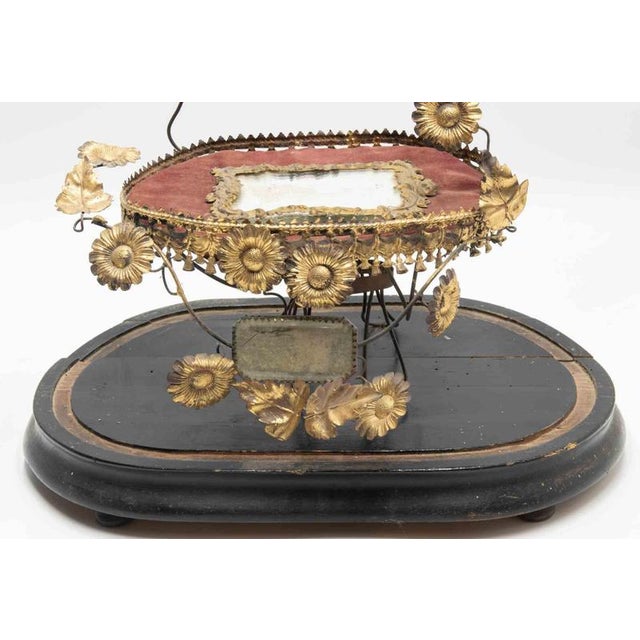 A romantic globe de mariée featuring a gilt-metal floral and foliate frame with applied daisy motifs, symbolic leaves, and...