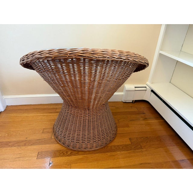 A sculptural vintage rattan bucket lounge chair with pedestal base and rounded barrel-back silhouette. This eye-catching...