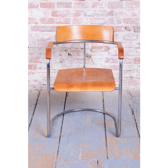 This elegant Bauhaus armchair originates from Czechoslovakia from the 1930s and was manufactured by the renowned Vichr a...