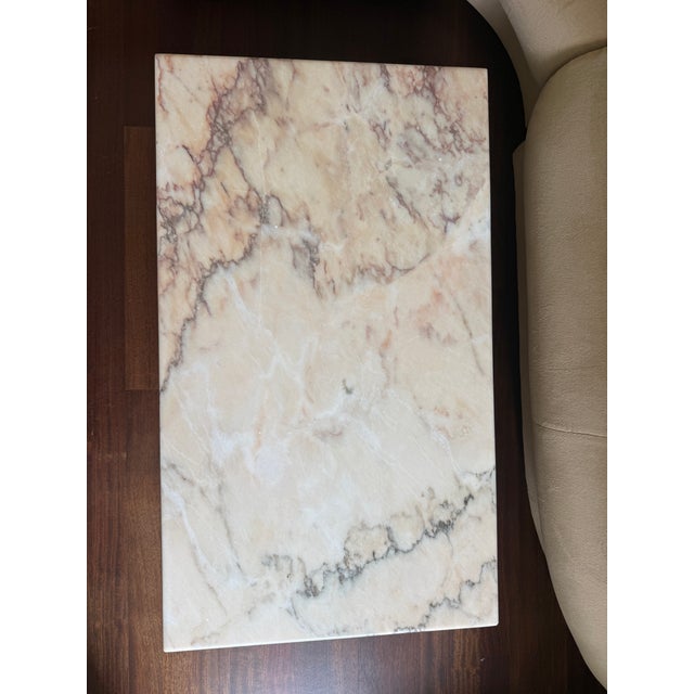 A sculptural rectangular coffee table in polished Bianco Rosa Portugallo marble — a premium Portuguese marble with a rosy-...