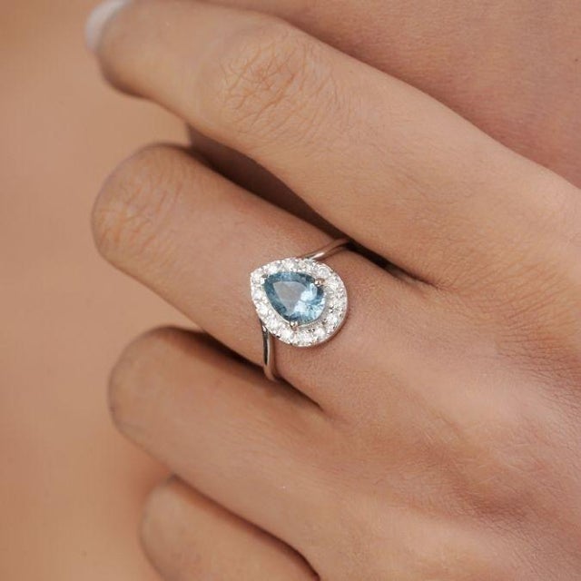 This vintage-style halo cocktail ring features 1 ct of a pear-shaped aquamarine and diamond set in 14k white gold. The...