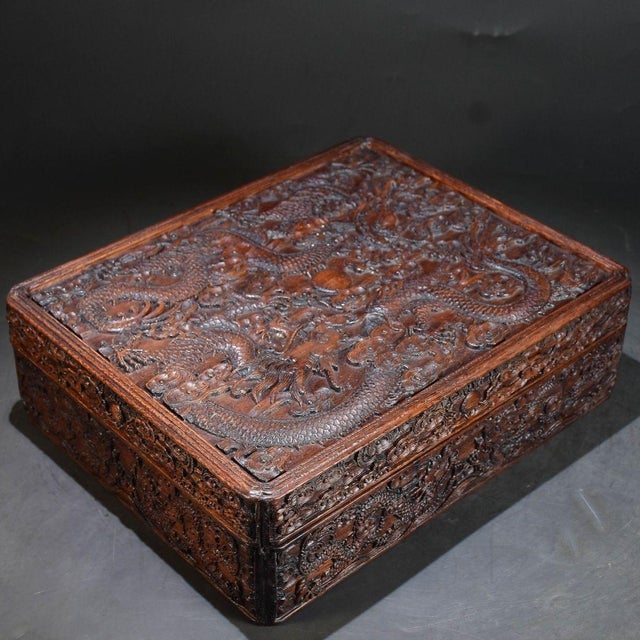 This is a substantial and exquisitely crafted rectangular wooden box, featuring intricate, deep relief carving across its...