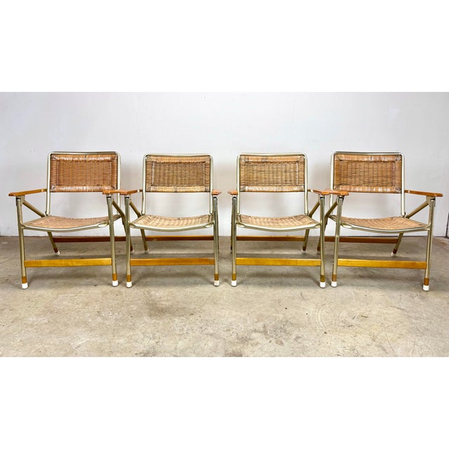 A set of 4 natural rattan/reed and aluminum chairs made by Telescope Furniture Company circa 1970’s featuring gold...