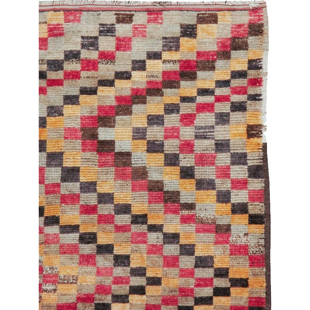 This mid-20th-century Turkish Anatolian accent rug presents a vibrant checkerboard composition built from small...