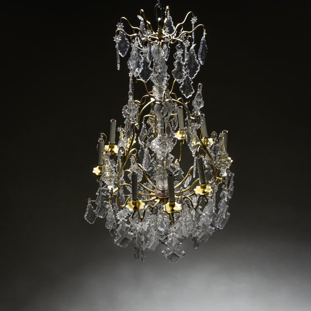 Large ceiling chandelier with finely cut glass drops and eight candle-shaped light sockets. The frame is made of bronze...