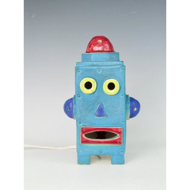 Fun cute quirky industrial themed table top Robot lamp. Colorful lamp accented by intermittent flashing red bulb inside....