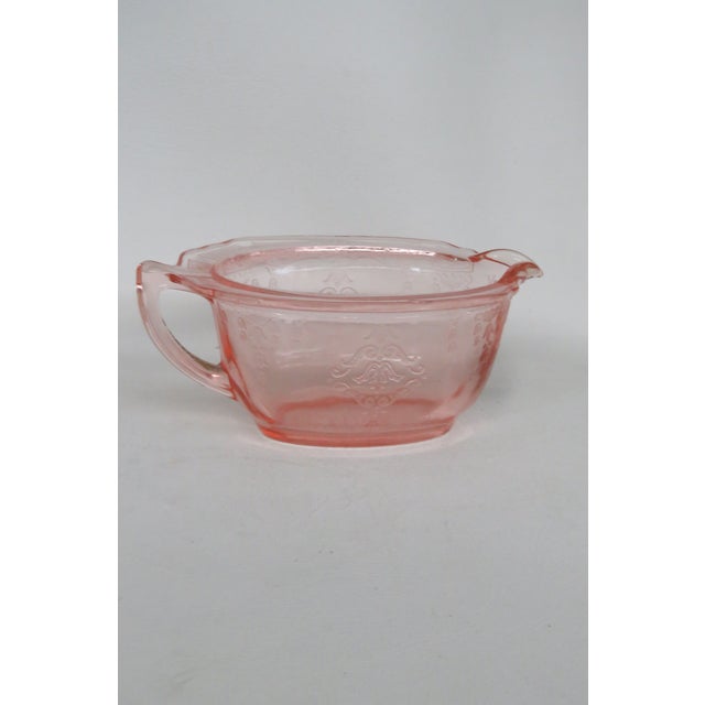 This adorable miniature pitcher / creamer dish is made of depression glass. This piece presents a gorgeous pink color with...