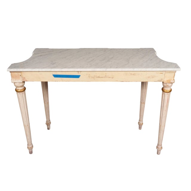 With rectangular white Carrara marble tops with a conforming creme painted frieze with finely carved leaves. Raised on...