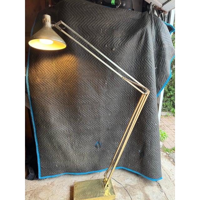 Striking mid-century modern floor lamp with a classic articulated design. The long, multi-jointed arm features a dual-tone...