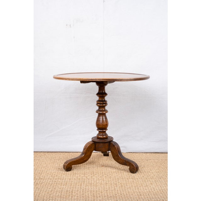 A fruitwood tripod table or guéridon, c. 1880, French. Made from cherry with a raised edge profile along the top, a turned...