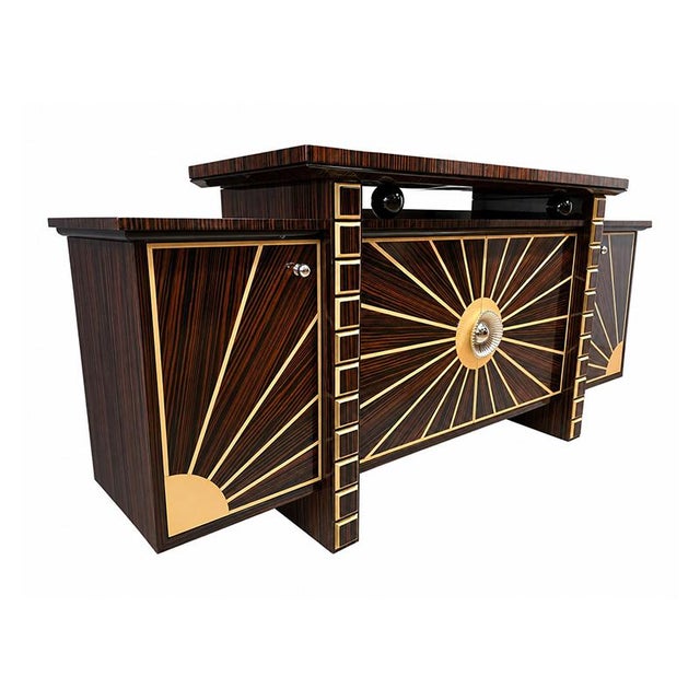 Spectacular Art Deco-style buffet, crafted from precious grained wood and refined gold details. The front is dominated by...