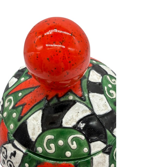 A striking vintage lidded art pottery vessel dating to the 1970s, featuring exuberant hand-painted decoration with...