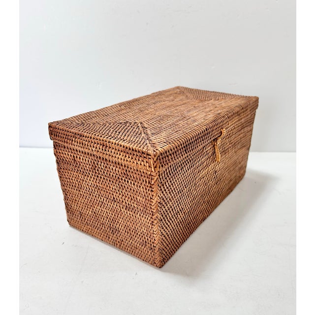 Vintage handwoven rattan storage box featuring a dense basket weave, fitted lid and traditional woven toggle closure. The...