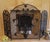 A highly decorative three-panel metal fireplace screen featuring an elaborate composition of birds, flowers and scrolling...