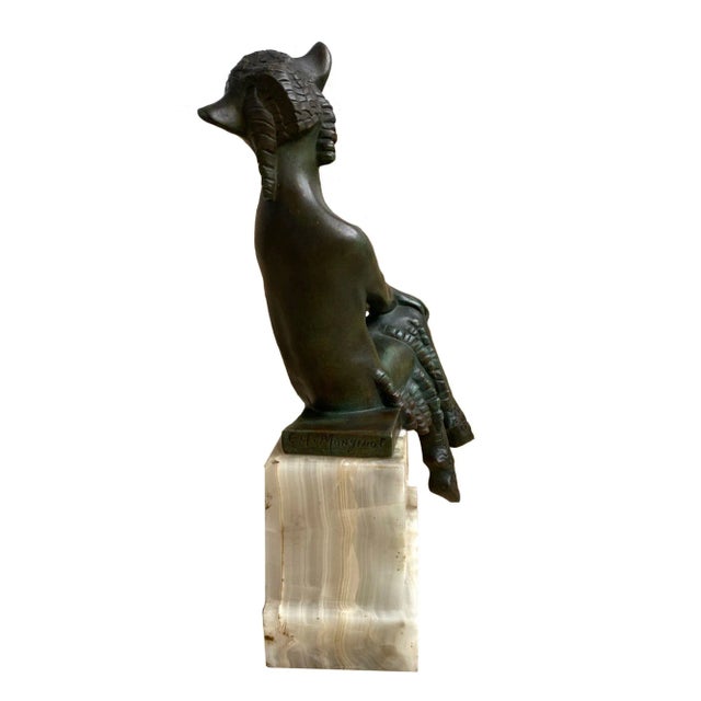 A wonderful French Art Deco bronze depicting a seated satyr. The satyr, sitting on a bronze plinth, is mounted on a white...