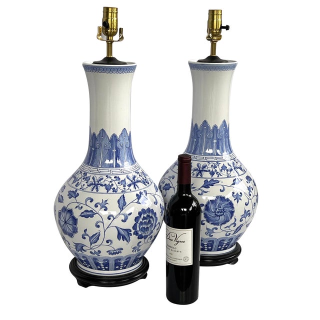 each with long flaring neck above a bulbous body adorned overall with hand-painted blue and white decoration with lappet...