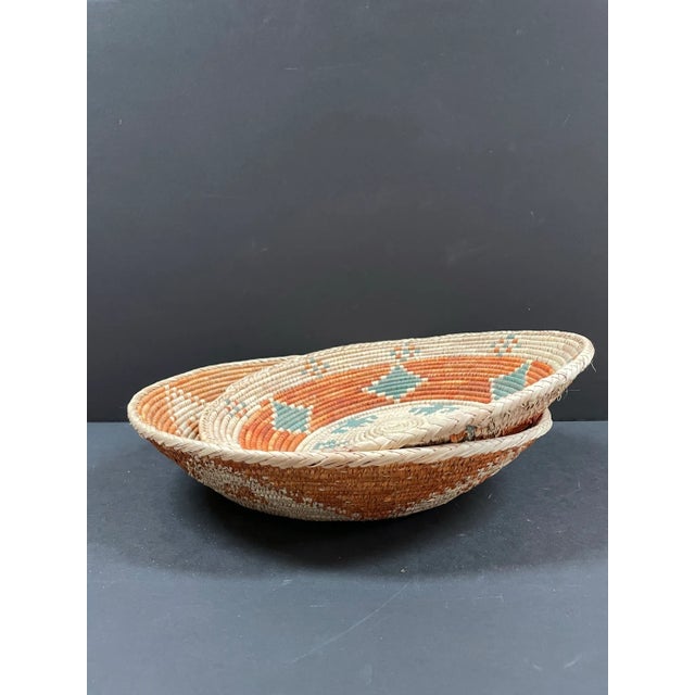 Pair of similarly colored hand woven shallow baskets from Africa. Each is unique in pattern. Though they are close in...