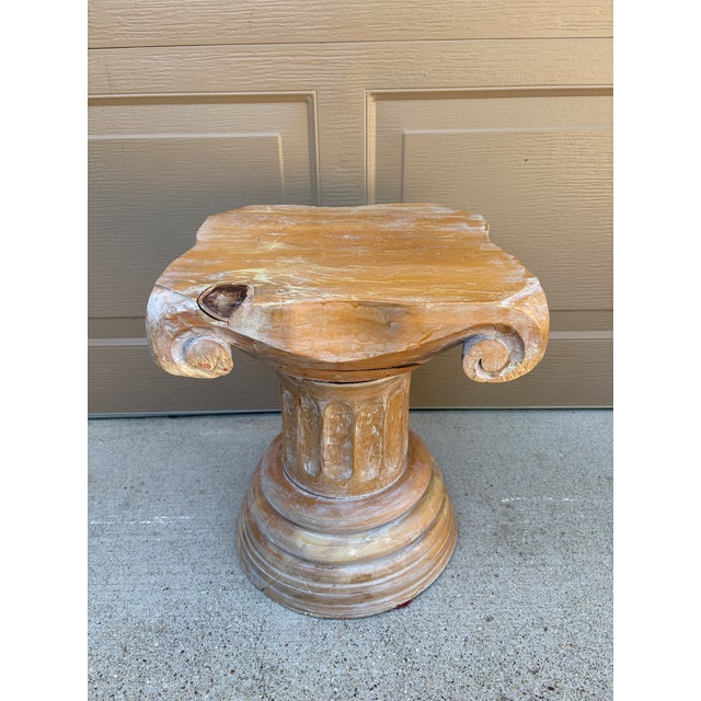 A sculptural carved wood pedestal inspired by the architectural vocabulary of the ancient world. The form references a...