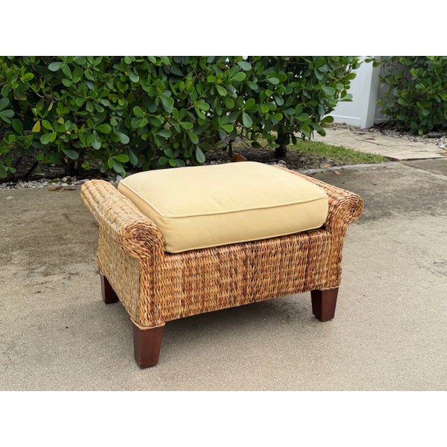 Vintage banana leaf ottoman with a substantial woven frame, tapered wood feet, and a removable upholstered cushion. The...