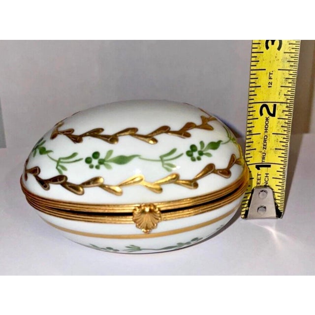 Elegant vintage Limoges porcelain trinket box crafted in France with a domed oval form, hand-painted green botanical...