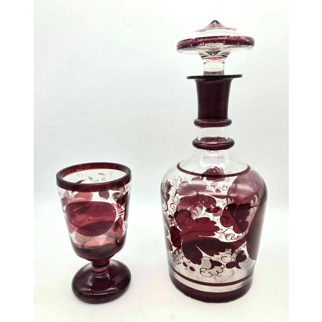 Offered is a mid 20th Century Czech or Bohemian decanter with stopper and a matching footed goblet or chalice. The ruby-...