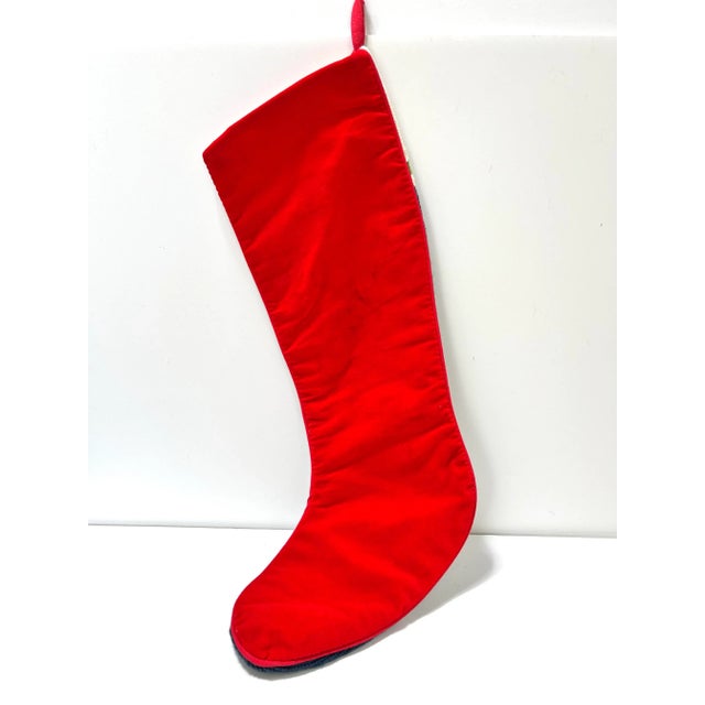 A festive wool holiday needlepoint stocking with a red velvet back. It’s a well-made heirloom piece. It’s a great piece of...