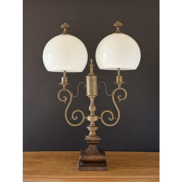 An elegant 1950s Italian table lamp featuring a beautifully aged brass frame, carved wood base, and two original opaline...