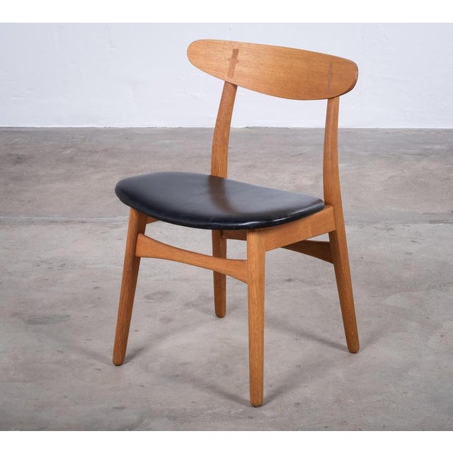 Elegant dining chair designed by Hans J. Wegner and produced by Carl Hansen & Søn, Denmark, in 1952. Crafted from oak and...