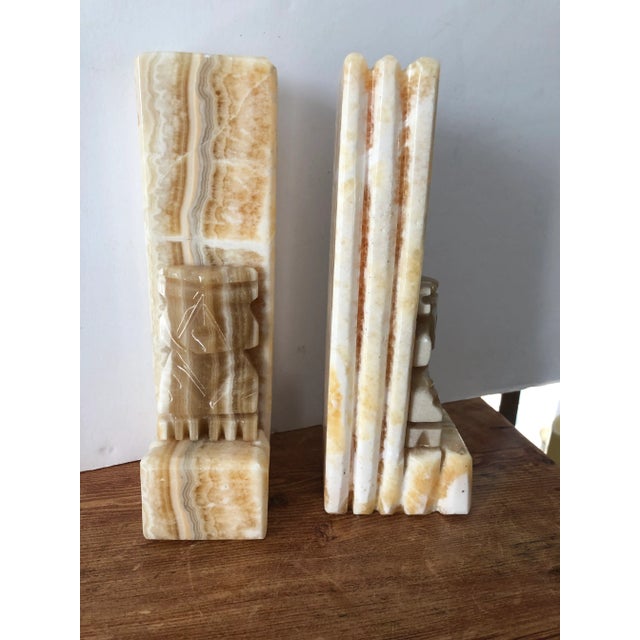 Aztec design stone bookends, has a tall back. One bookend has a chip at top corner which can be turned to hide the chip